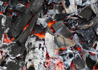 Burning and glowing charcoal with open hot flame and smoke close up.