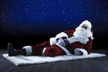 Santa Claus goes sledging. Beautiful winter alpine landscape. Blurry rocks in the foreground.