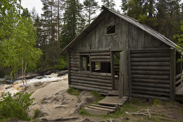 Fototapeta na wymiar Abandoned hunting Lodge in the woods. Mountain river.