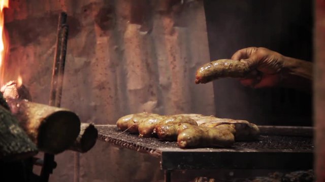 Authentic Argentine Barbecue Scene: Checking Chorizo with Fork - Close Up