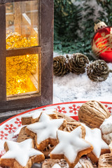 Weihnachtliche Szene mit Zimtsternen und golden beleuchteter Laterne