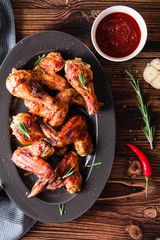 Chicken legs and chicken wings in a sauce fried on a wooden background. Top view. Copy space. 