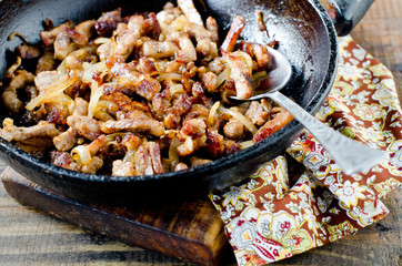 Meat fried with onions in a frying pan