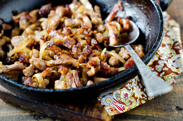 Meat fried with onions in a frying pan