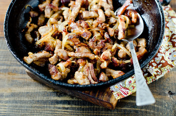 Meat fried with onions in a frying pan