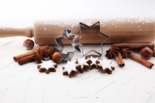 Christmas baking ingredients and tolls for dough preparation. Flour, rolling pin and cookies and spices.