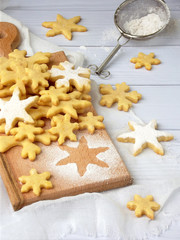 Fototapeta na wymiar Christmas shortbread cookies in the form of snowflakes sprinkling sugar and cookie cutters. Xmas card concept