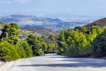 Empty mountain road with blue sky and sea on a background. Greece, island of Salamina.