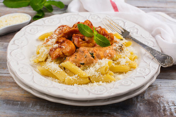 Cooked italian pasta arrabiata with chicken and tomato sauce on wooden table. Copy space
