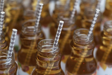 Glass Bottles with apple Juice with Straw on White Isolated Background