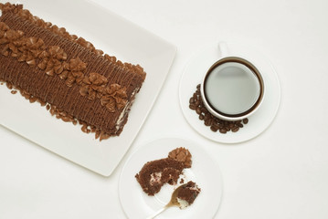 Cup of Coffee and Delicious Chocolate Cake, Metal Spoon and a piece of Cake, on White Background