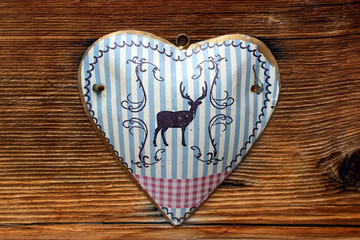 Herzförmiges Blechschild mit Hirsch auf natürlichem Holz