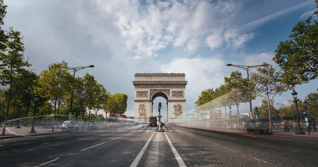 Fototapeta na wymiar Famous avenue Champs-Elysees and the Triumphal Arch, symbol of the glory and historical heritage. Iconic touristic architectural landmark of Paris, France. Tourism and travel concept. Long exposure.