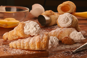 Cream Filled Trubochki (Pizzelles), eggs and baking forms on a wooden table