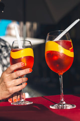 Female hand with polished nails holding alcoholic summer drink.