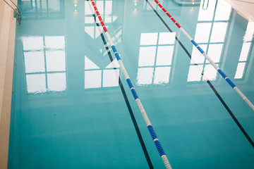 The view of an empty public swimming pool indoors lanes of a competition swimming pool sport