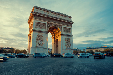 Famous Paris avenue Champs-Elysees and the Triumphal Arch, symbol of the glory on bright sunny day with cloudy sky. Iconic touristic landmark and romantic travel destinations in France. Long exposure