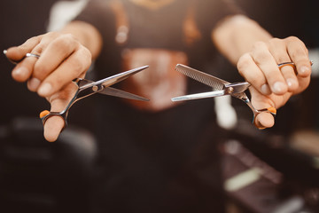 Barber shop. Close-up of barber holds clip-on hair clipper barbershop