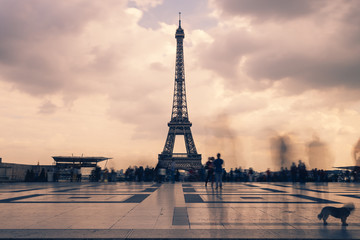 Fototapeta na wymiar Eiffel tower, Paris symbol and iconic landmark in France, on a cloudy day. Famous touristic places and romantic travel destinations in Europe. Cityscape and tourism concept. Long exposure. Toned