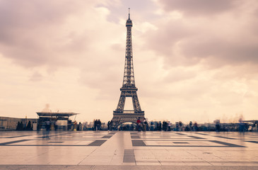 Eiffel tower, Paris symbol and iconic landmark in France, on a cloudy day. Famous touristic places and romantic travel destinations in Europe. Cityscape and tourism concept. Long exposure. Toned