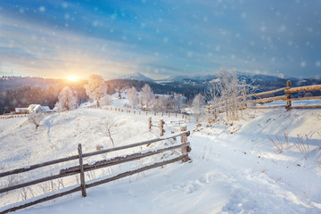 Winter country landscape with timber fence and snowy road