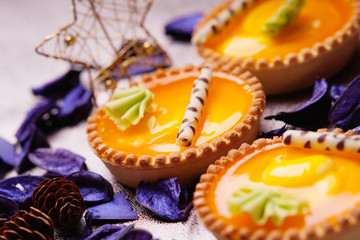 Orange cake baskets on a flower petals background 
