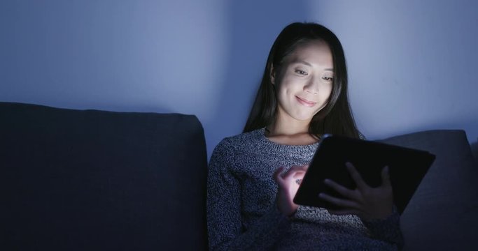 Woman posting on social media with tablet computer
