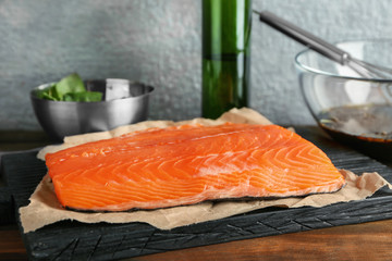 Fresh raw salmon fillet ready for marinating on wooden board