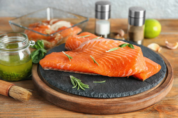 Fresh raw salmon fillet and marinade on wooden table
