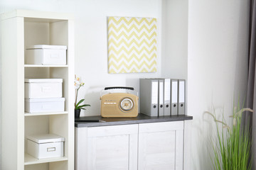 Retro radio on chest of drawers in room