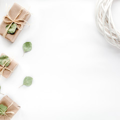Fototapeta na wymiar Creative arrangement frame of craft boxes and green branches eucalyptus on white background. flat lay, top view