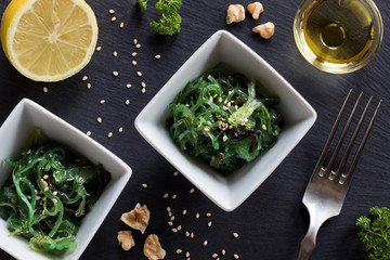 Fresh seaweed salad in two square bowls on a dark background © Madeleine Steinbach