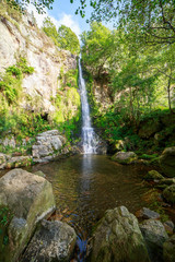 Landscape of one of water cascades of Oneta waterfalls in picturesque forest of Asturias, Spain.