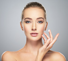 Obraz na płótnie Canvas woman gets cream in the face. Skin care concept.