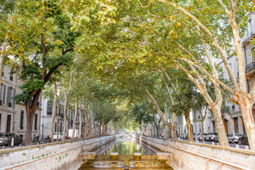 View on the beautiful water channel during the sunny day in Nimes city in the Occitanie region of...