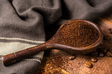 Dark roasted pure arabica coffee beans and ground coffe on the wooden table, copy space