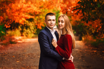 beautiful couple on the street. the girl and the guy in the arms. Golden autumn