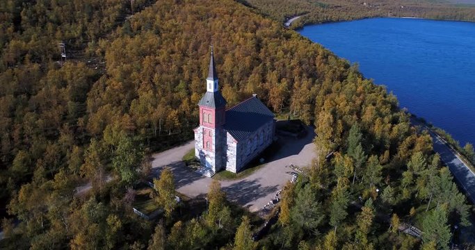 Arctic church, Cinema 4k aerial view around utsjoki church, near mantojarvi lake and utsjoki town, in Lapland, on a sunny autumn day, in Lappi, Finland