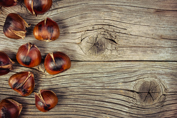 Roasted chestnuts on old wooden background