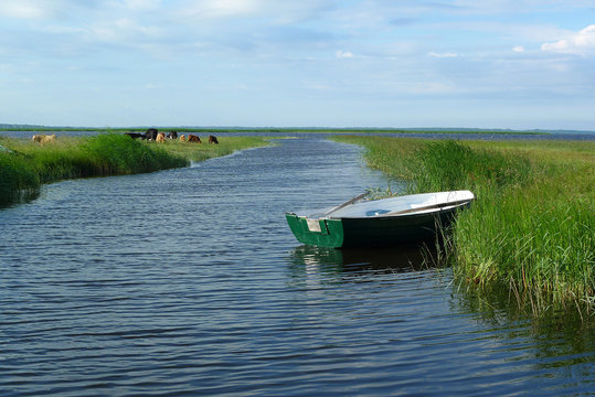 A water canal with boats in a rural countryside
