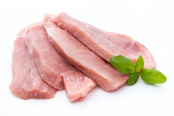 Fresh pork fillet with basil on a white background.