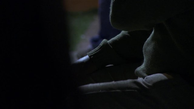 Man Drumming His Thighs With His Hands While Sitting on a Bench at Night in Montevideo, Uruguay - Close-Up