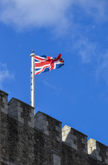 The british flag on an ancient tower in England. 