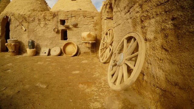 wooden wheels, old utensils and clay house in the Arab village, near the border between Turkey and Syria