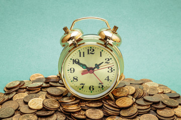 alarm clock  on a heap of coins