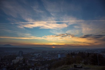 Красивый заход солнца над городом, вечерний пейзаж, яркие цвета на небе