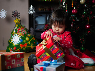 Fototapeta na wymiar baby girl looking her christmas gift