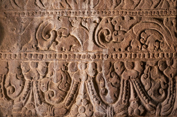 Background of Indian rock-cut architecture. Wall with carved patterns in 6th century cave temple, India