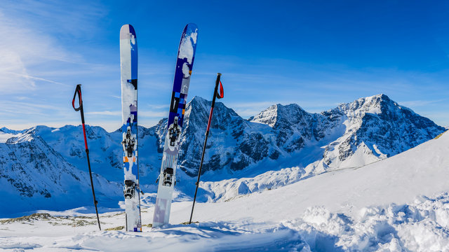 Ski in winter season, mountains and ski touring backcountry equipments on the top of snowy mountains in sunny day. South Tirol, Solda in Italy.