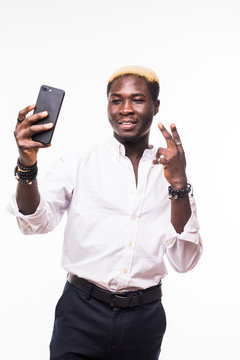young handsome african man taking a selfie with a cell phone, isolated on white